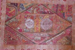 An Indian textile wall hanging, comprising a patchwork of saris with silver and gold threads and