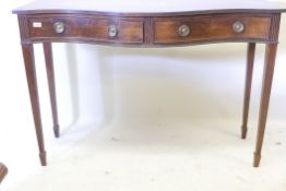 A C19th serpentine front mahogany serving table, with reeded edge top and two drawers with ring