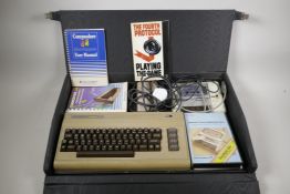 A Commodore 64 with accessories and carry case, 24½" x 16"