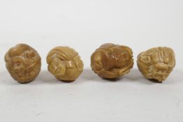 A set of four Japanese tagua nut figural carvings, 1½" diameter
