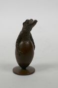 A Japanese Jizai style bronzed metal figure of a crocodile hatchling breaking through its egg,