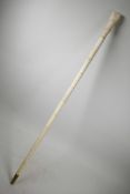 A bone walking cane, the handle carved in the form of a clenched fist holding a snake, 36" long