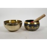 A Tibetan brass singing bowl, and another with script decoration, largest 5½" diameter