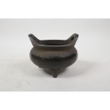 A Chinese bronze censer with two phoenix eye handles and tripod feet, impressed 4 character mark