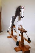 A large dappled painted pine rocking horse, maker's plaque affixed to base, 'Sunrise horses,