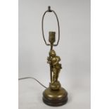 An early C20th French bronze table lamp in the form of a putti carrying a wheatsheaf, 18" high