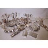 A good quantity of silver plated ware, including a pair of tureens, two pairs of candlesticks, two