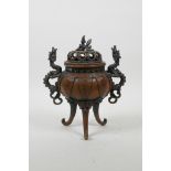 A Chinese coppered metal censer and cover on tripod scrolling feet, with dragon shaped handles and