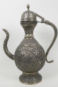 An Islamic white metal teapot with all over embossed floral decoration, 14" high