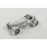 A silver miniature racing car, 1" long