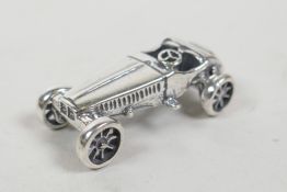 A silver miniature racing car, 1" long
