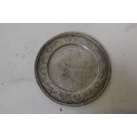 An antique Indian silver plate with raised and finely engraved decoration of trailing flowers with