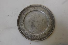 An antique Indian silver plate with raised and finely engraved decoration of trailing flowers with