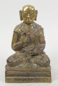 A small bronze figure of Buddha seated in meditation with engraved decoration, studded with