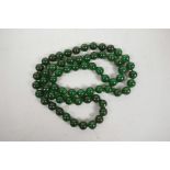 A string of dark green jade beads, 32" long