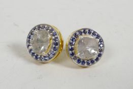 A pair of silver gilt ear studs set with mine cut diamonds encircled by sapphires