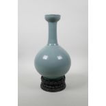 A Chinese Ru ware style porcelain vase on a carved hardwood stand in the form of a lotus flower,