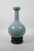 A Chinese Ru ware style porcelain vase on a carved hardwood stand in the form of a lotus flower,