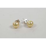 A pair of freshwater pearl stud earrings with silver posts