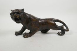 An Oriental filled bronze of a tiger, 12" long