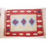 An Afghan rug with a bright geometric medallion design, 46" x 65"