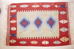 An Afghan rug with a bright geometric medallion design, 46" x 65"
