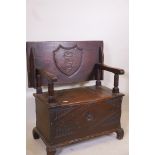 A late C19th/early C20th oak monk's bench with carved decoration and forged iron strap hinges, 32" x