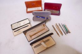 A collection of ball pens, Cross, Sheaffer, Dupont, and propelling pencils, a K knife retracting