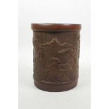 A Chinese carved bamboo brush pot decorated with figures in a landscape, 6½" high, 5½" diameter