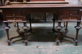 A Continental mahogany four drawer kneehole desk, raised on turned supports with shaped