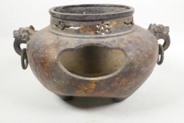 A large bronzed metal censer with two mask ring handles, pierced sides and gilt patination, 7" high,