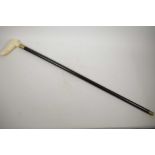 A hardwood walking cane with carved bone handle in the form of a thumb, 34" long