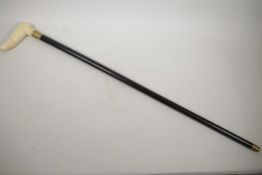 A hardwood walking cane with carved bone handle in the form of a thumb, 34" long