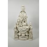 A Chinese blanc de chine porcelain figure of Quan Yin and two attendants, impressed seal marks
