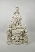 A Chinese blanc de chine porcelain figure of Quan Yin and two attendants, impressed seal marks