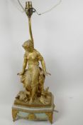 A gilt metal table lamp cast as a Grecian girl seated on a rock, with amphora and two doves at her