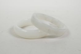 A Chinese mottled white hardstone bangle and another similar, 3" diameter
