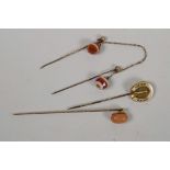 A C19th gold and coral stick pin together with an unmarked gold horseshoe stick pin and a double
