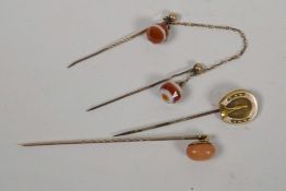 A C19th gold and coral stick pin together with an unmarked gold horseshoe stick pin and a double