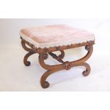 A Regency walnut stool raised on cross scrolling end supports united by a turned stretcher, traces