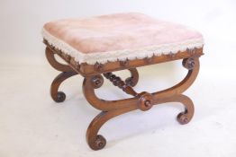 A Regency walnut stool raised on cross scrolling end supports united by a turned stretcher, traces