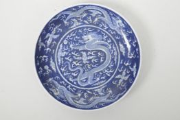 A Chinese blue and white porcelain dish decorated with dragons chasing the flaming pearl, 6