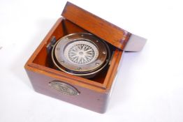A gimballed brass compass mounted in a wood case, 5" x 5" x 3"