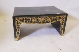 A Chinese black lacquered low table with raised parcel gilt decoration and single frieze drawers,