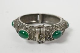 A Chinese white metal bangle set with jade, 3½" diameter