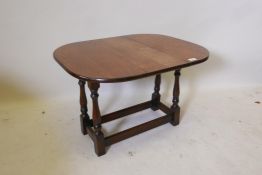 An oak dropleaf occasional table with swivel top, raised on turned supports united by stretchers