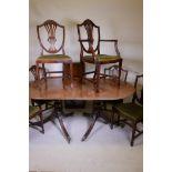A mahogany twin pedestal dining table with solid top, reeded edge and extra leaf, raised on turned