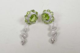 A pair of silver, cubic zirconium and peridot earrings with snake shaped drop, 2" long