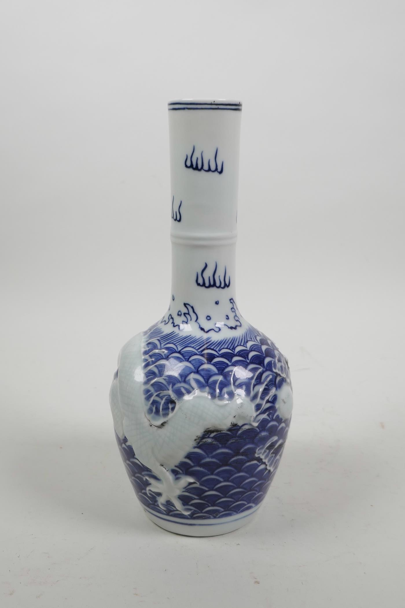 A Chinese blue and white porcelain bottle vase with raised decoration of a dragon chasing the - Image 3 of 5