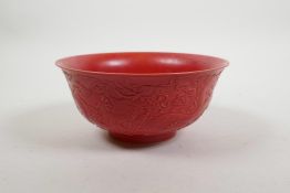 A Chinese red ground porcelain rice bowl with raised dragon decoration, impressed seal mark to base,